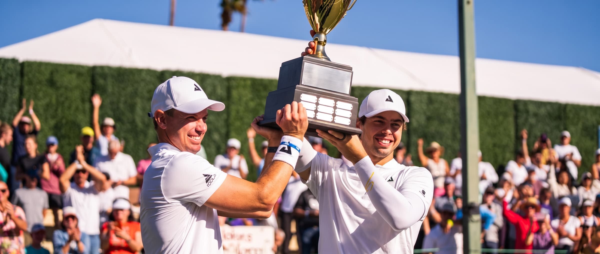 Ben and Collin Johns lifting a championship trophy
