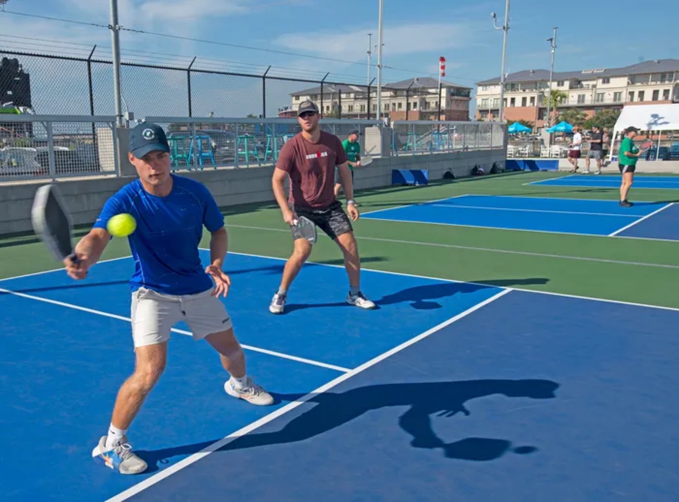 Players rallying at the net on an outdoor Portside Pickle court